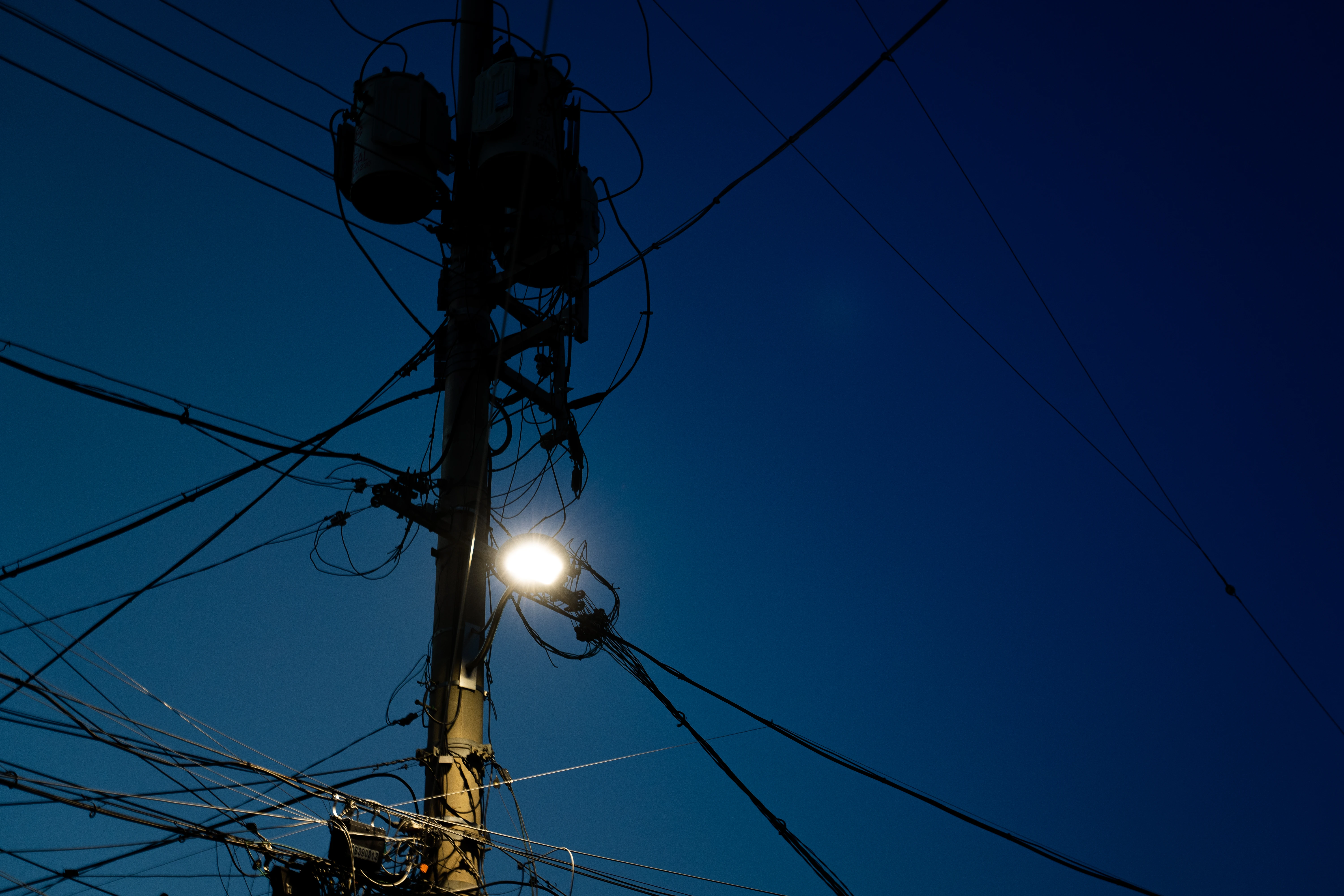 Illuminated Utility Pole Silhouetted Against a Deep Evening Sky