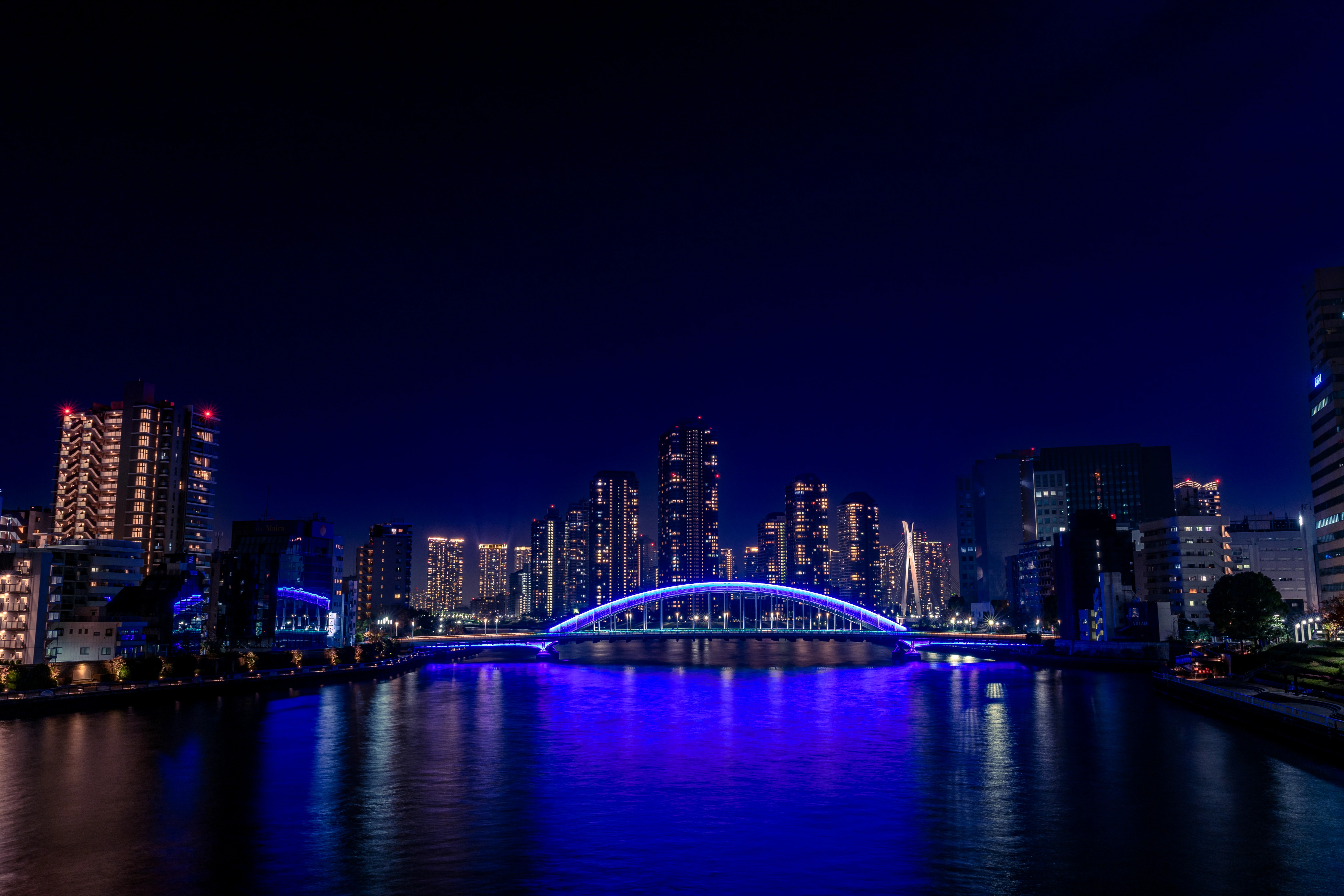 Luminous Bridge and City Lights Reflecting on Calm Waters