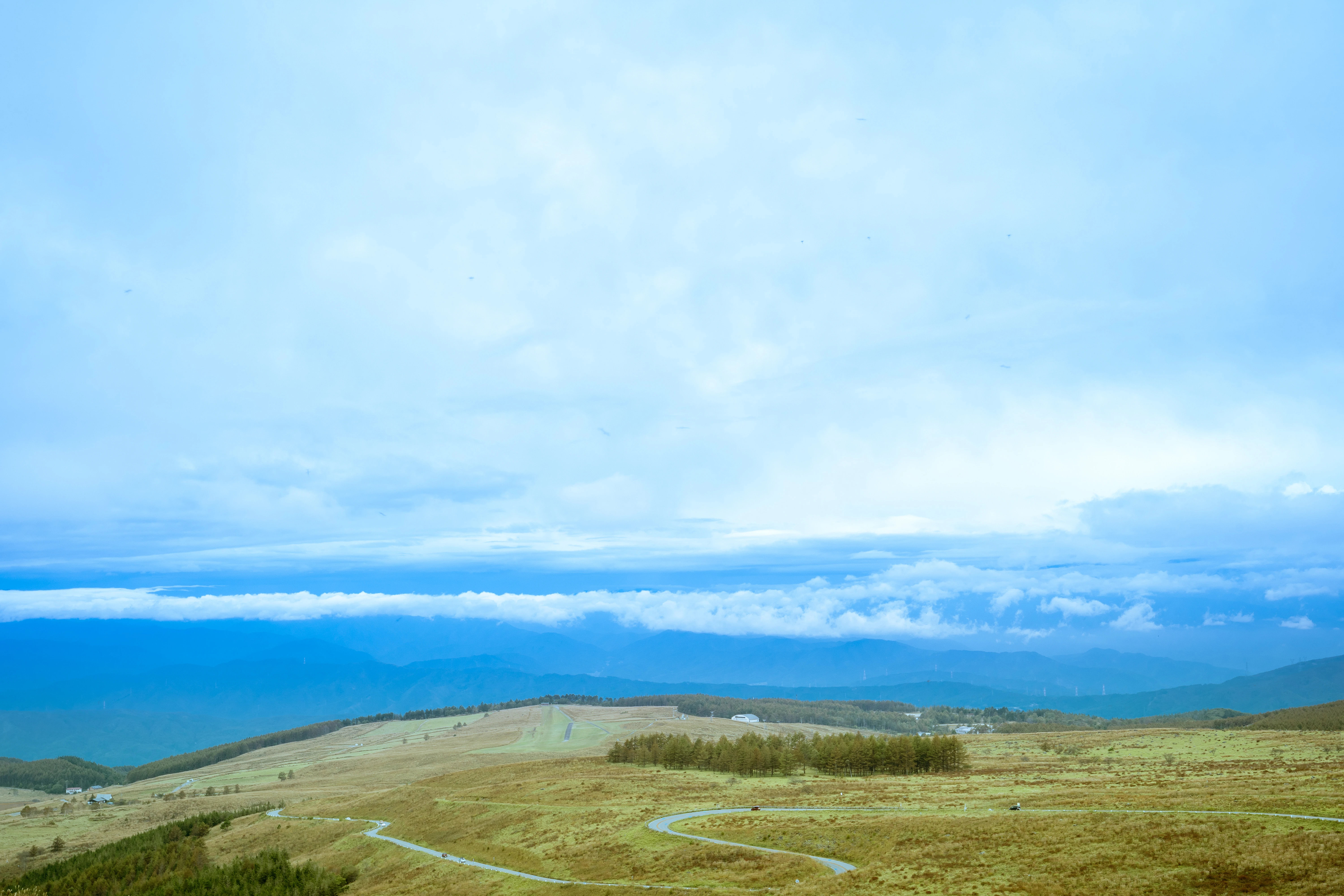 Expansive Mountain Plains Under a Soft Blue Sky