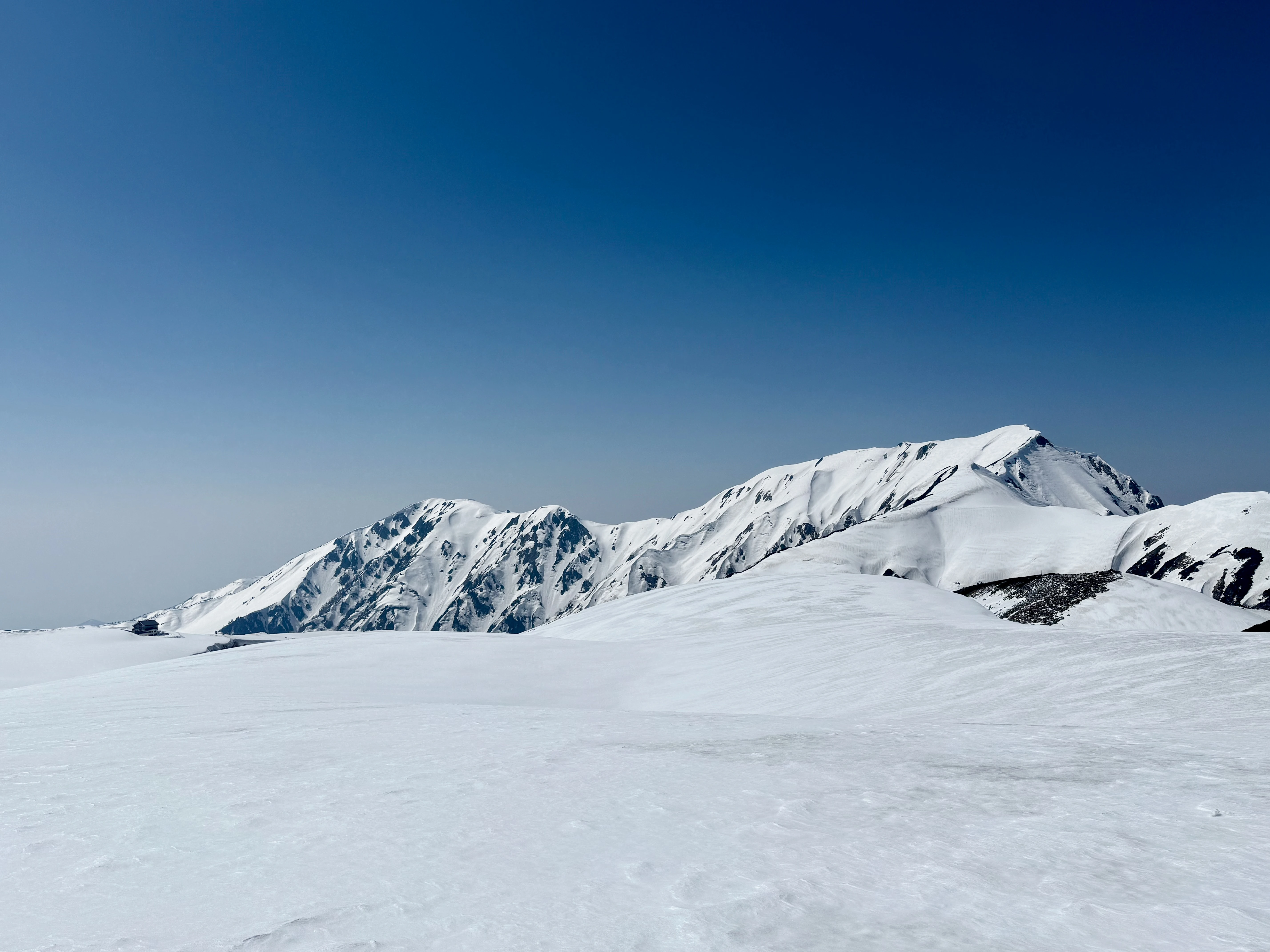 Vast Snowy Peaks Beneath a Clear Blue Sky in Early Spring