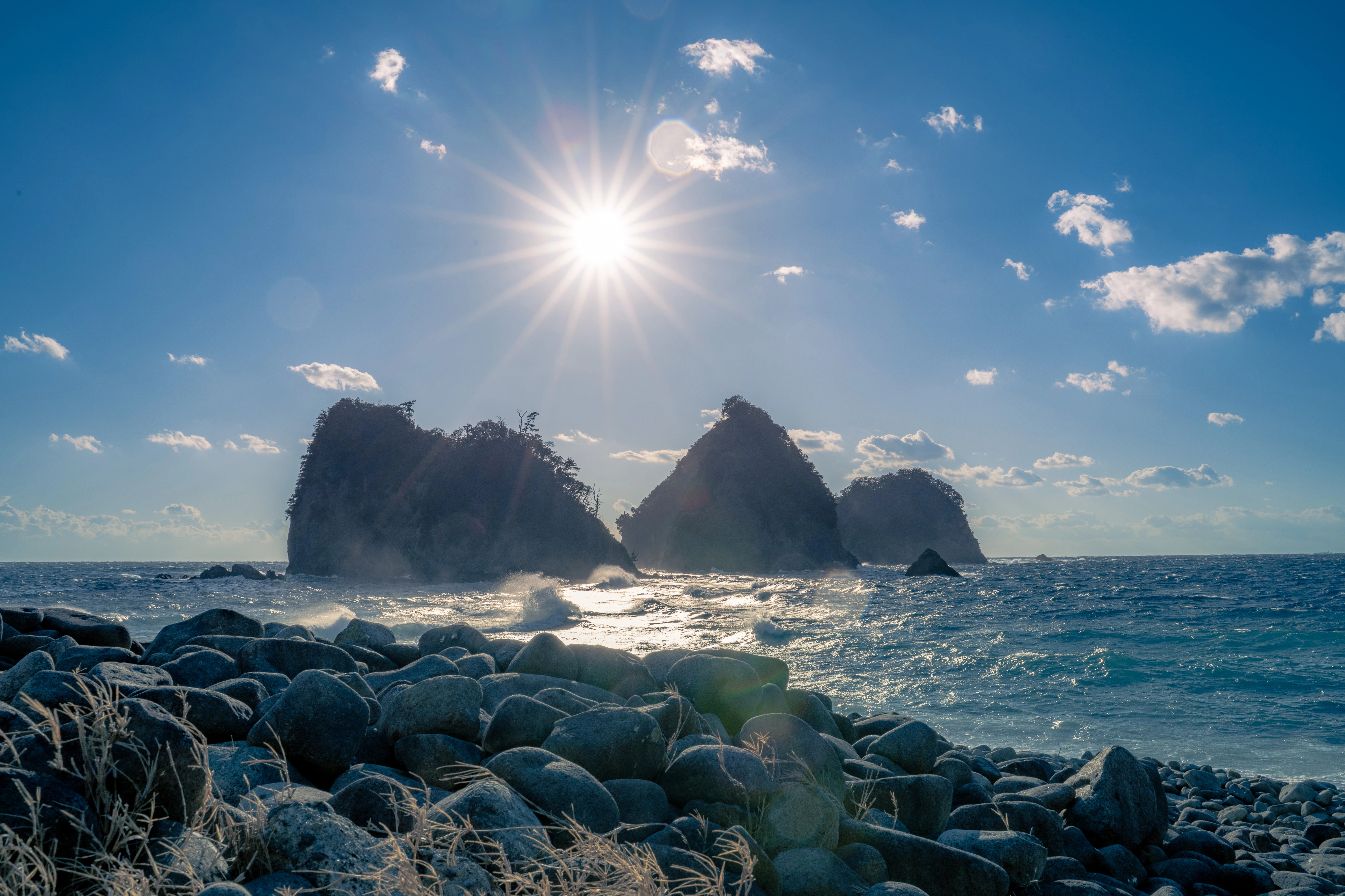 Pebble Beach Framing Sunlit Coastal Rocks