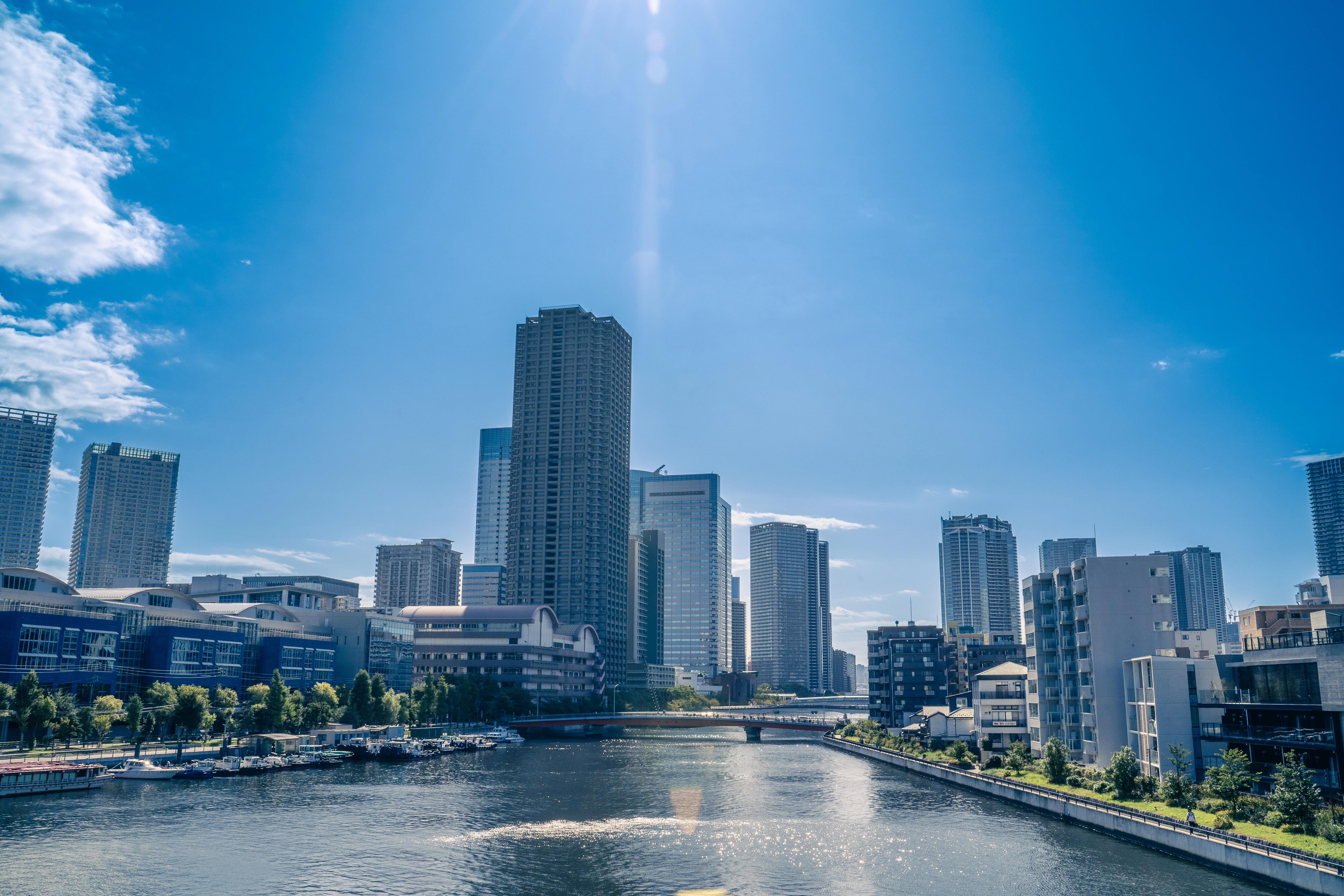 Modern Cityscape Reflecting on Serene Waterfront under Sunny Skies