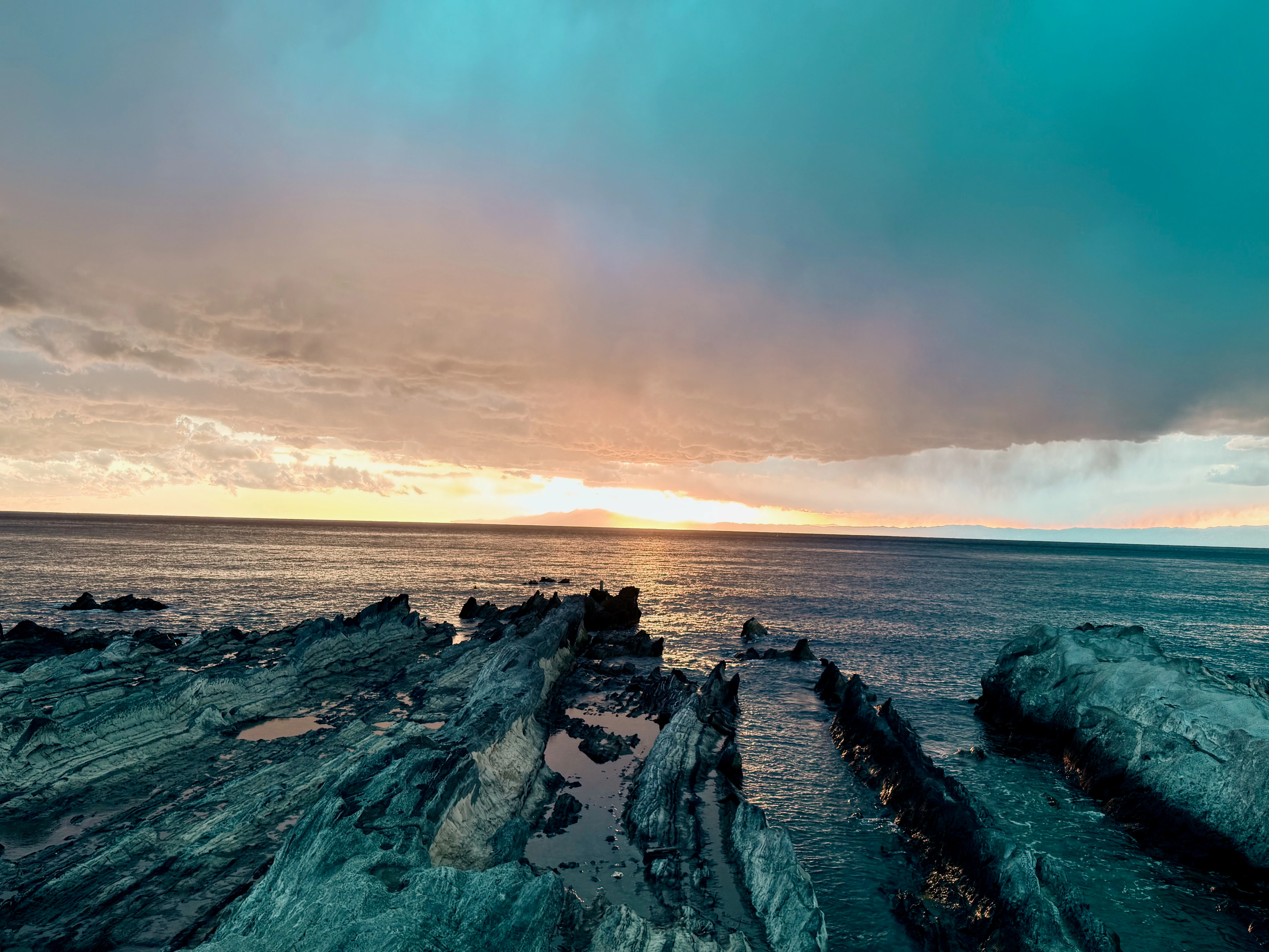 Dramatic Seascape with Jagged Rocks and Golden Horizon