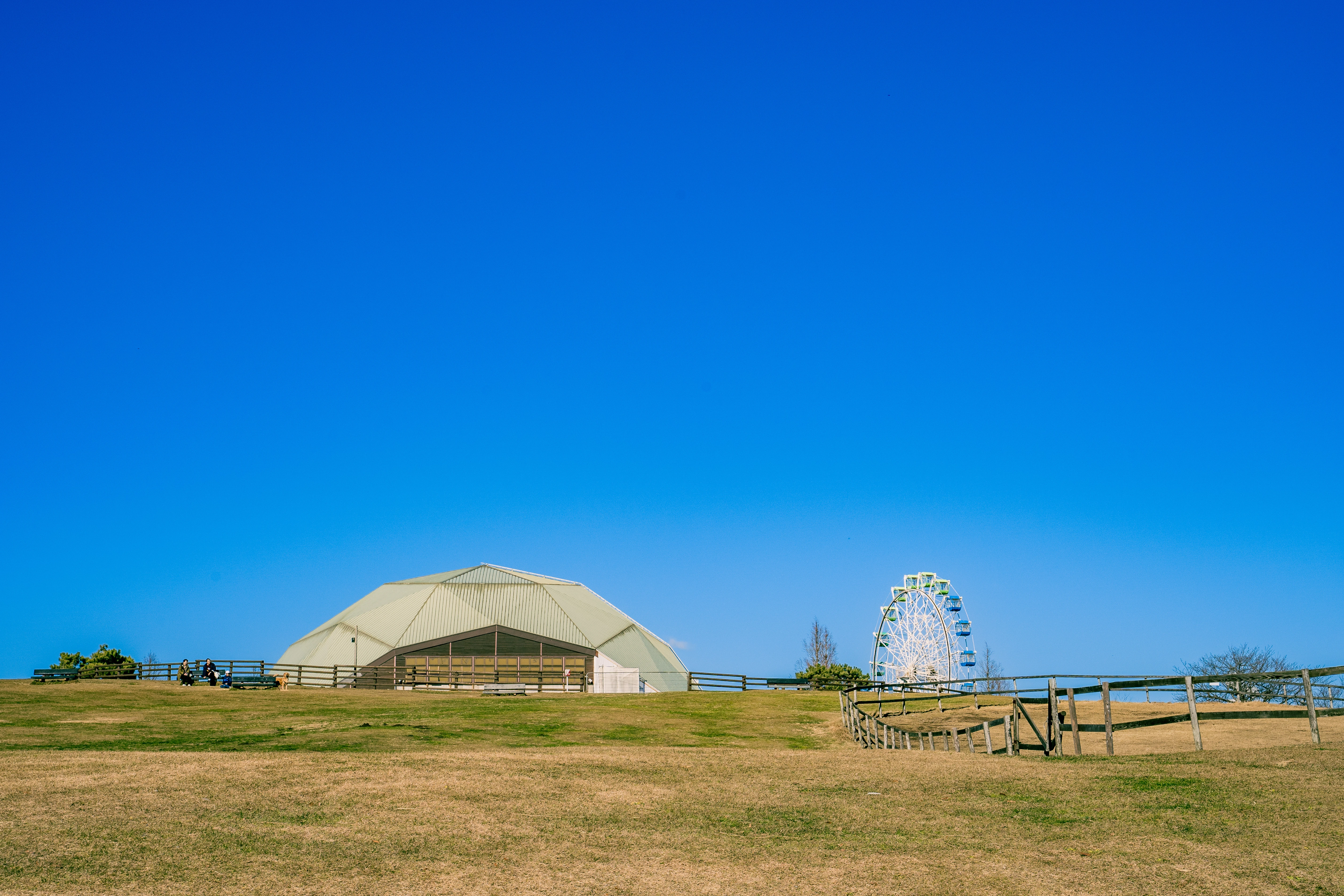 Tranquil Countryside Amusement Park Under Bright Blue Sky