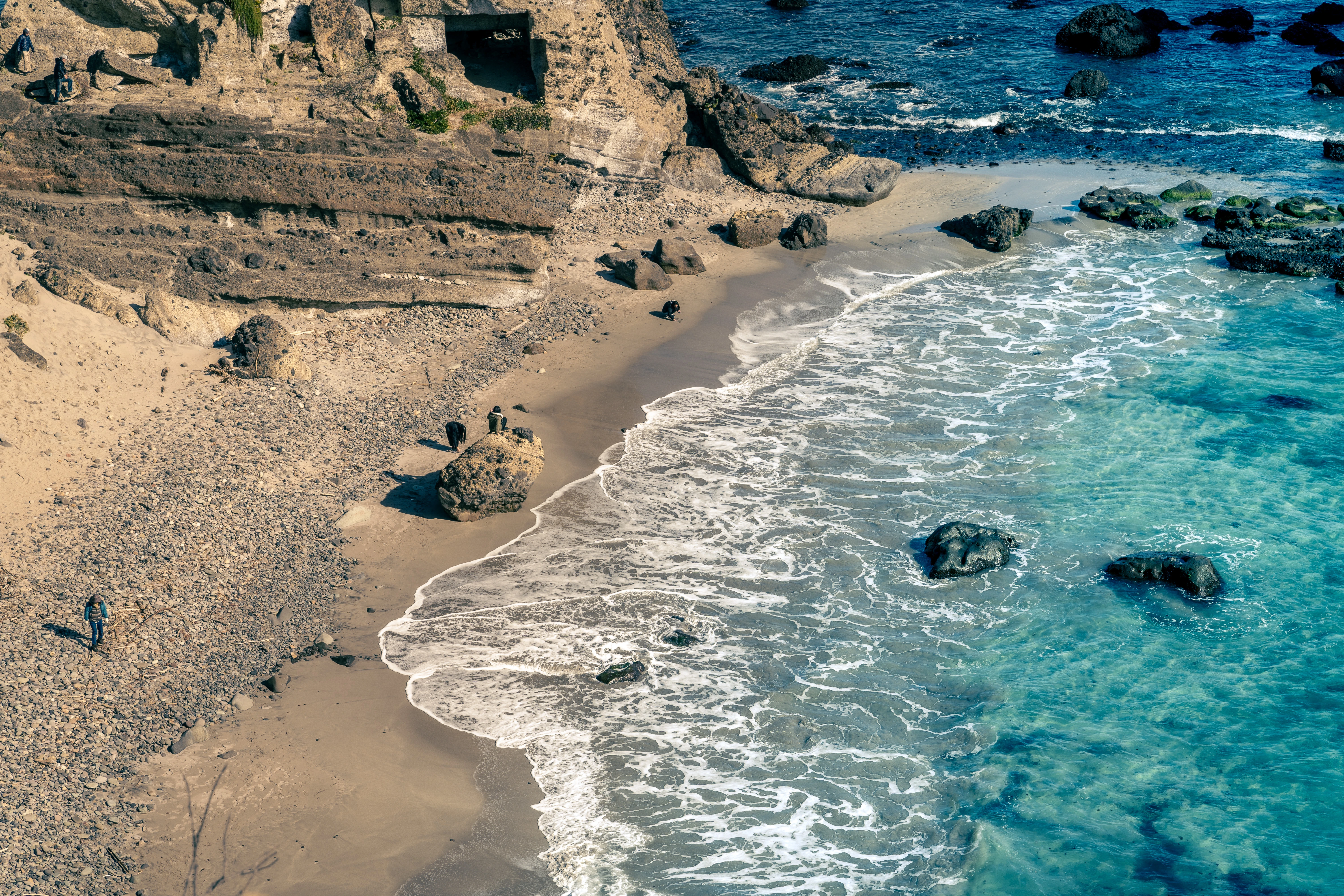 Cliffside Shoreline with Turquoise Waves and Rocky Beach