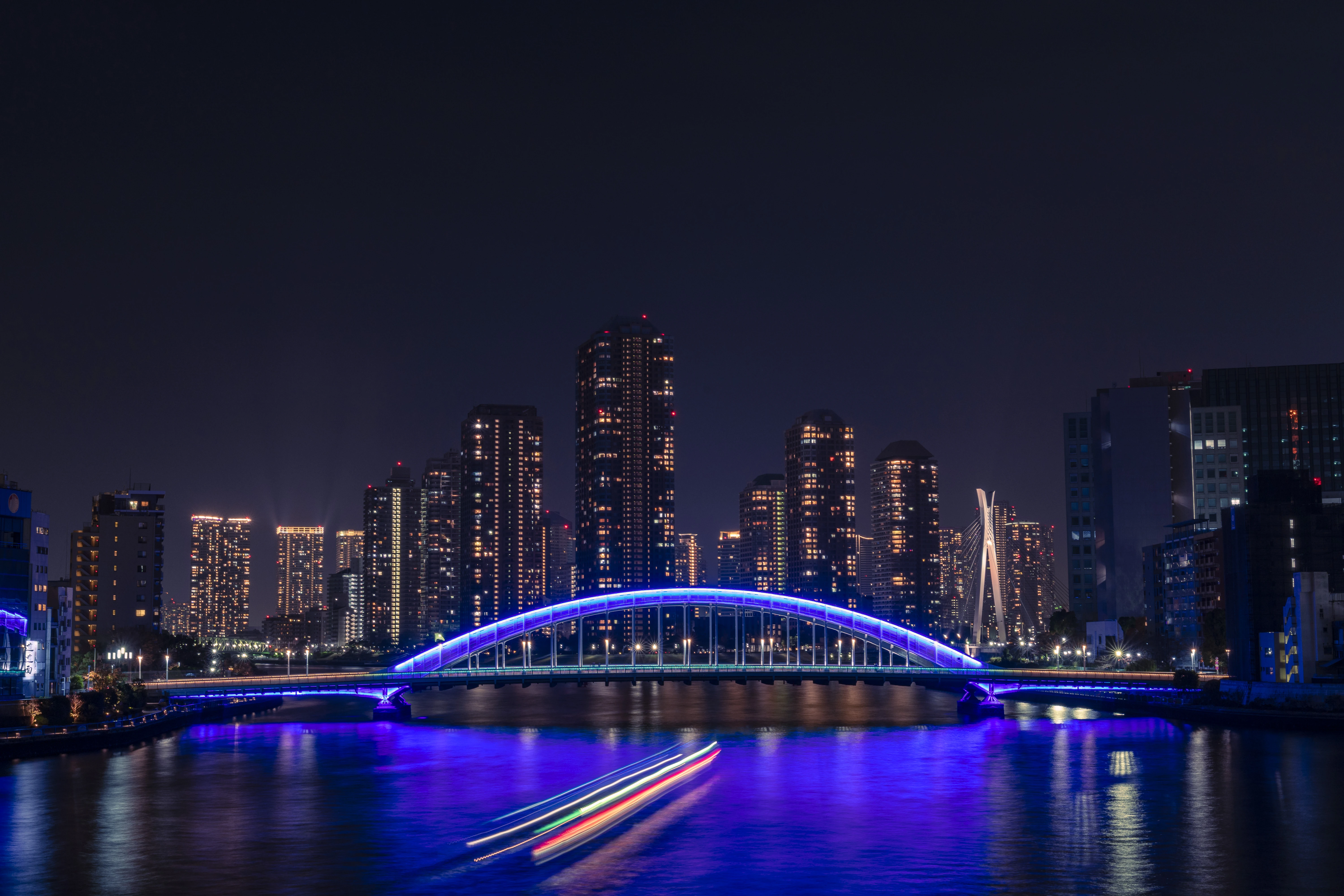 Luminous Nightscape: Vibrant City Lights and Illuminated Bridge Reflections