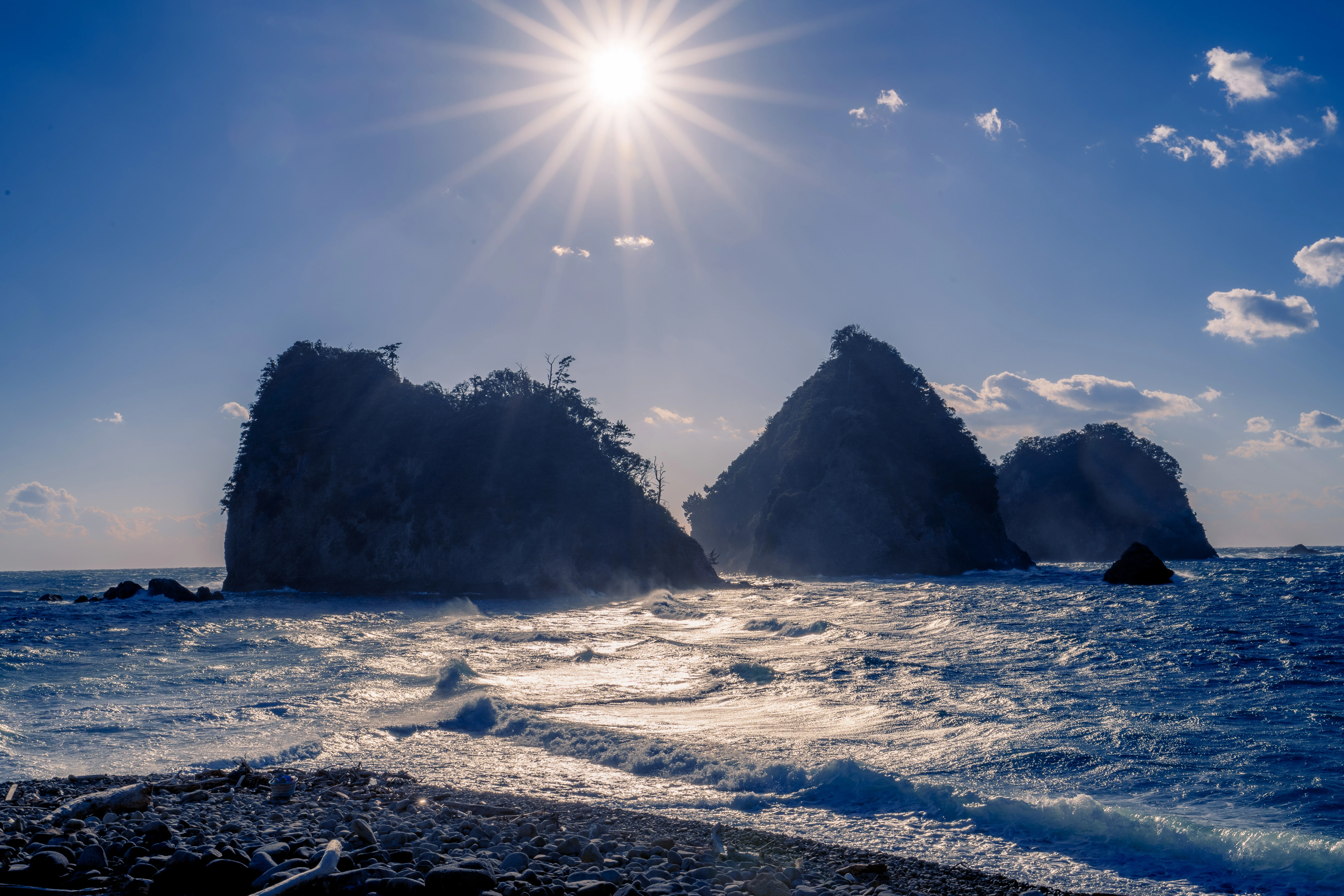 Sunlit Coastal Rocks with Waves and Crisp Sky