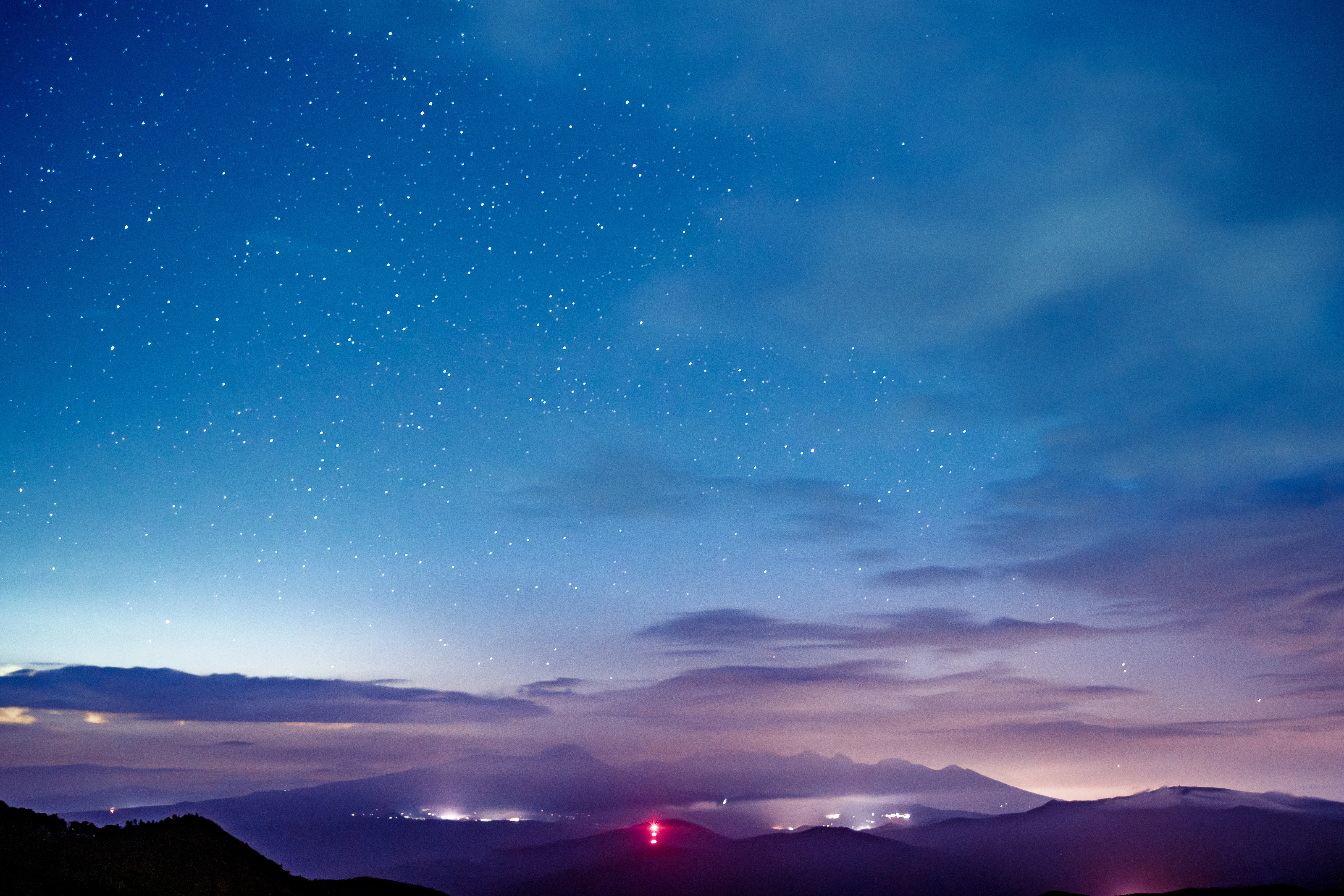 Starry Night Over Illuminated Mountain Village