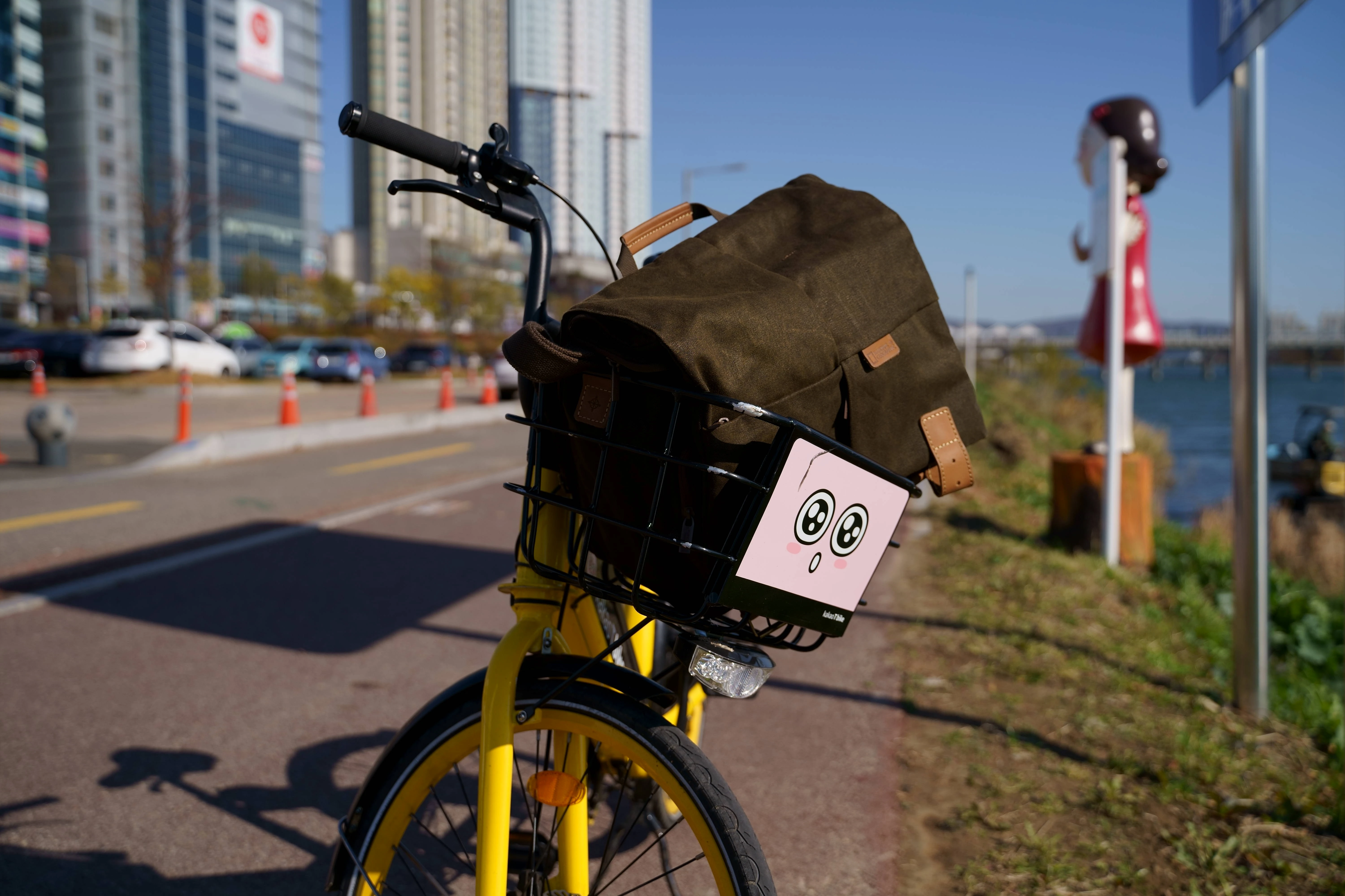 Yellow Bicycle with Cute Basket Near City Waterfront
