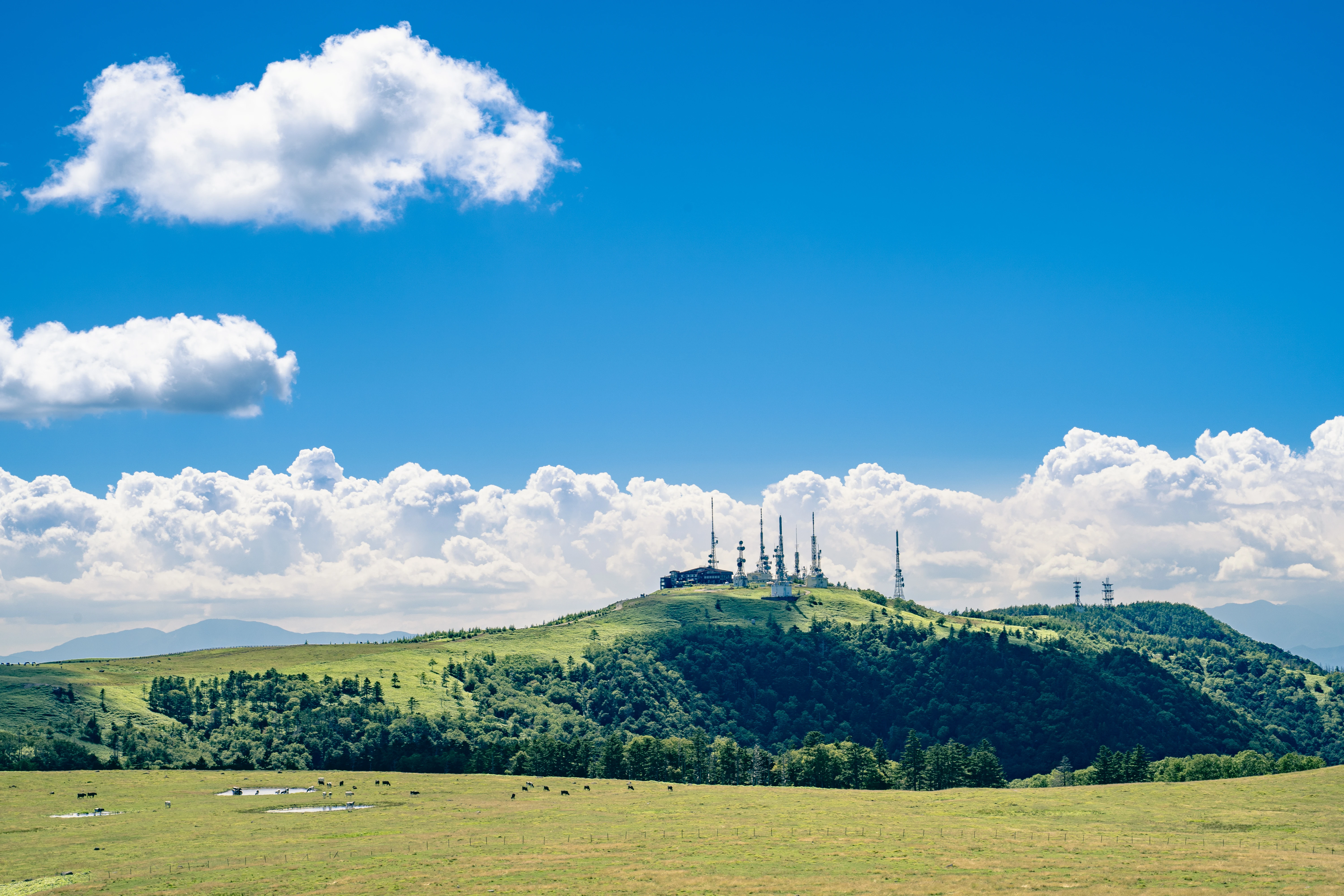 Rolling Hills with Towering Antennas under Blue Skies