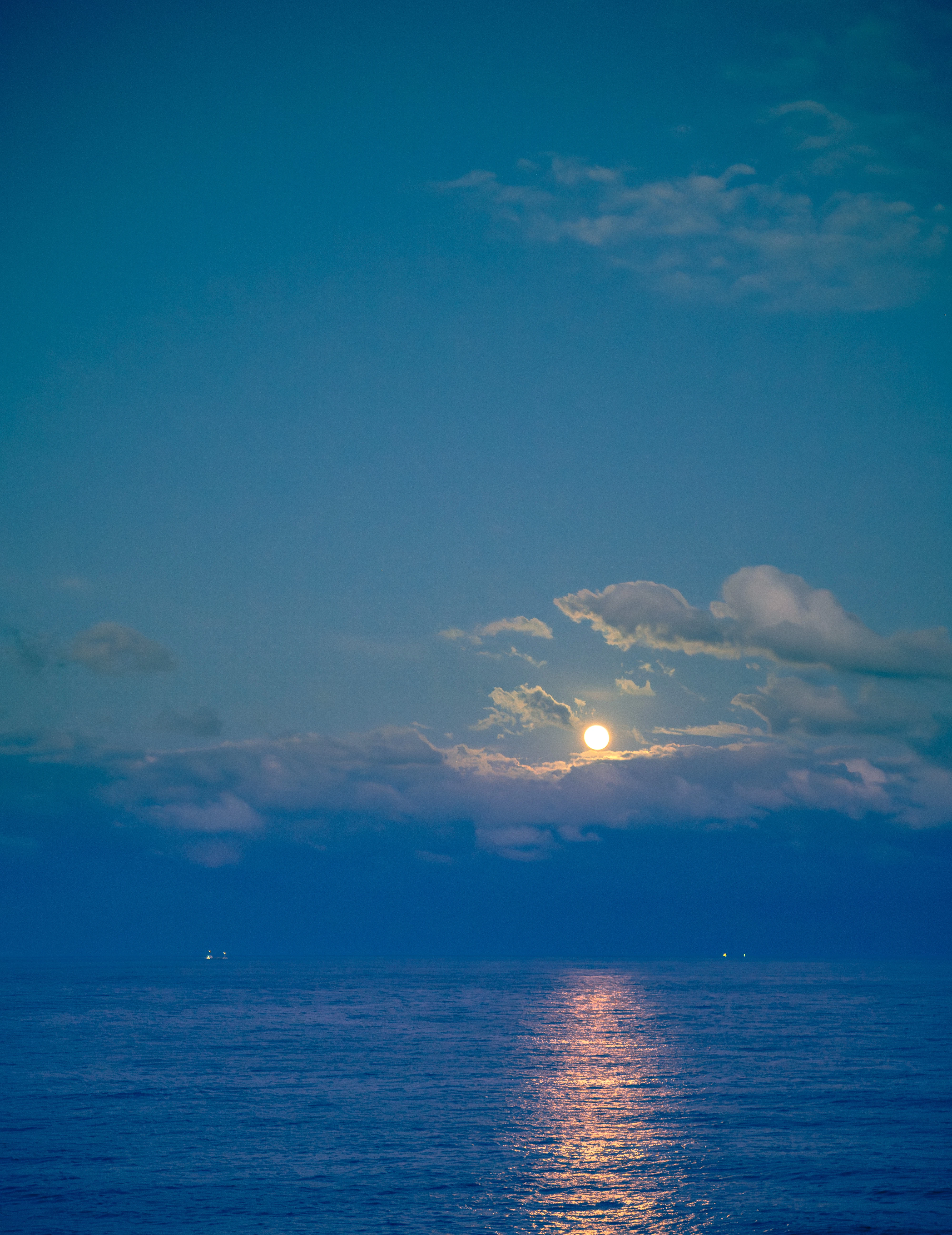 Tranquil Ocean Under Moonlit Clouds