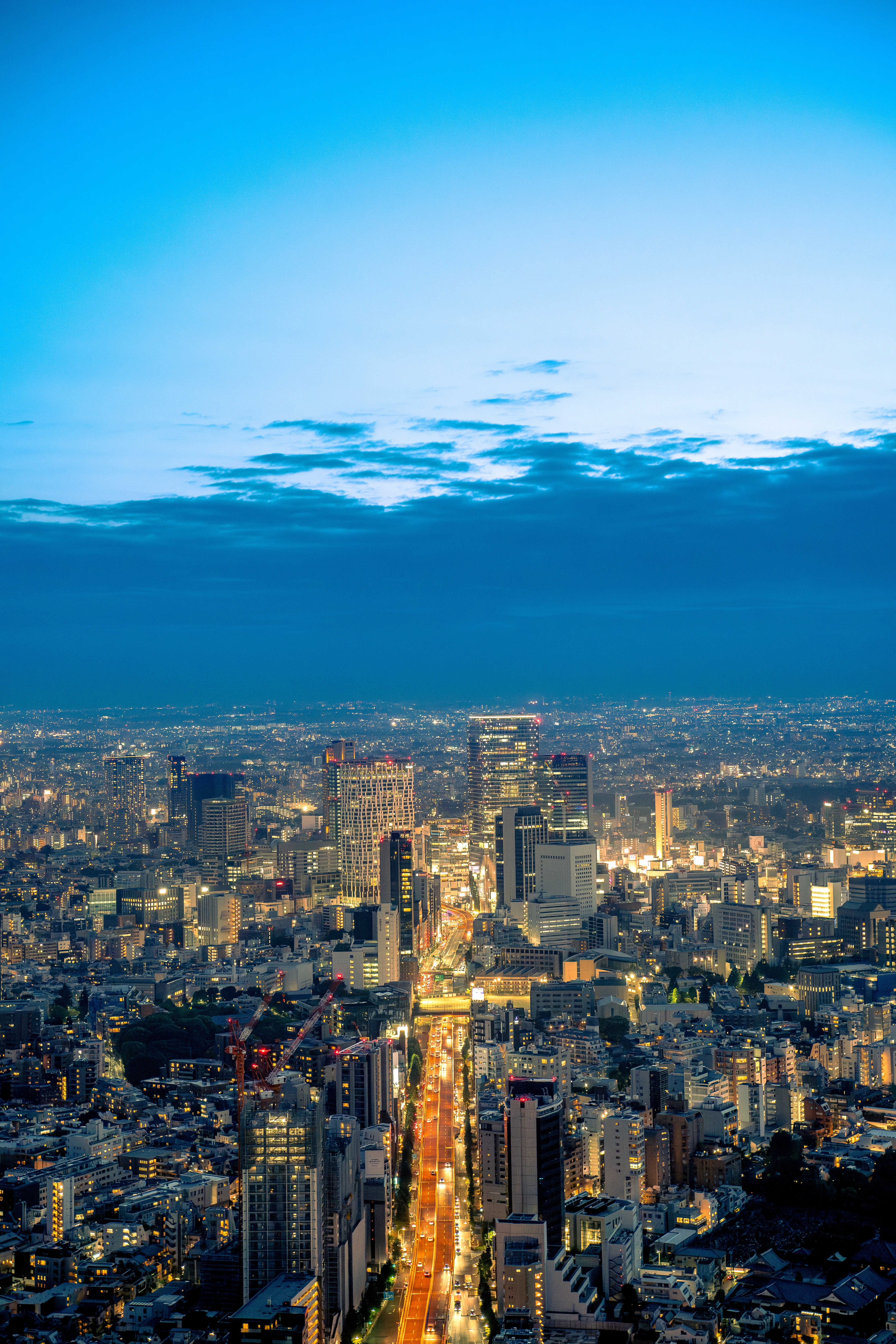 Illuminated Cityscape as Dusk Settles Over Urban Spires